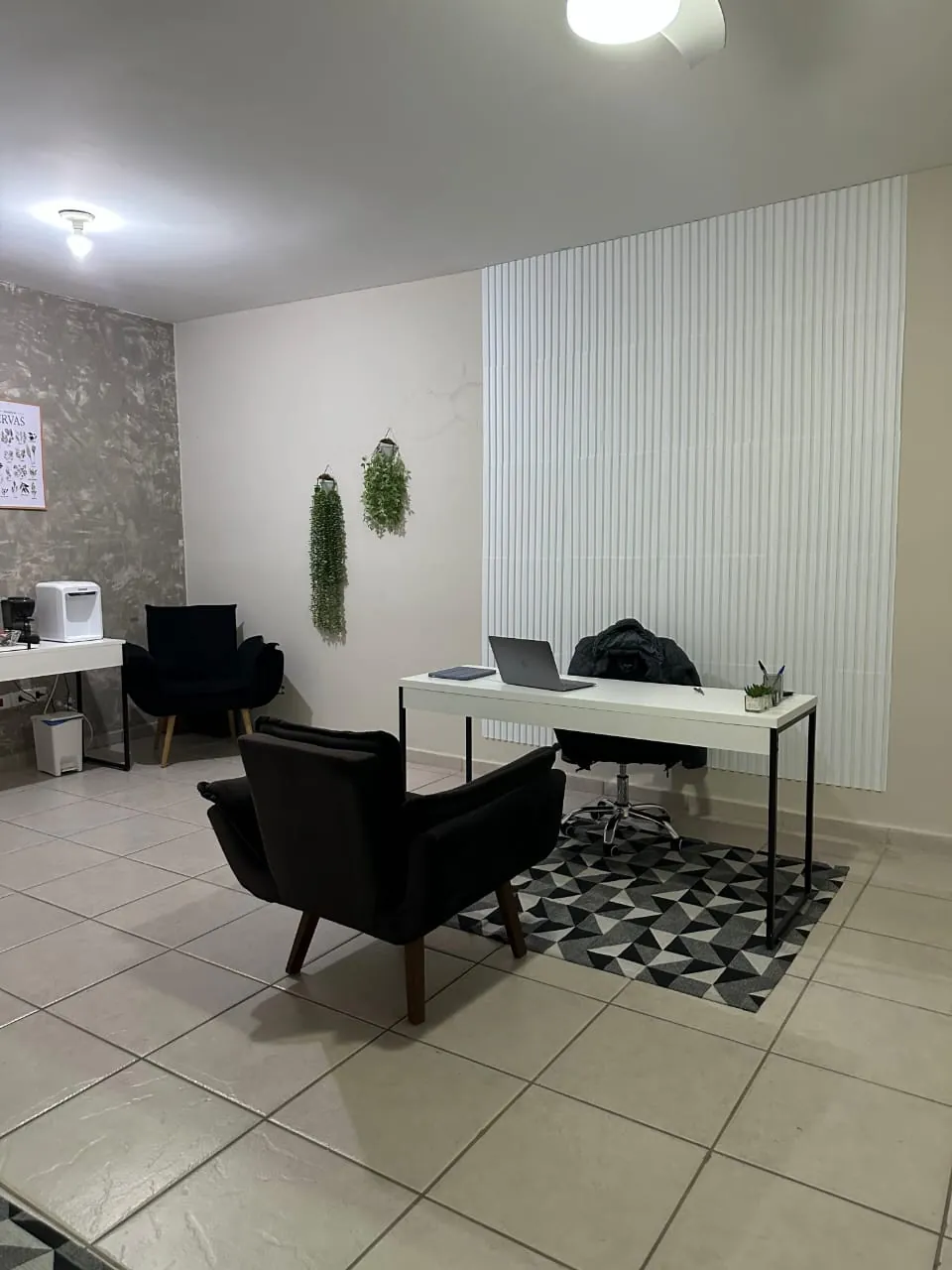 Sala de atendimento com mesa e poltrona